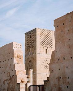 an old building is shown in the middle of some desert like structures with intricate carvings on it