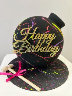 a birthday cake that is on top of a black plate with the words happy birthday written on it