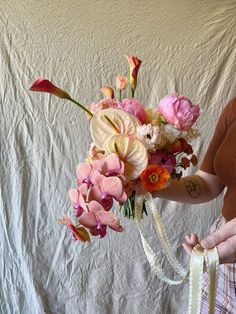 a woman holding a bouquet of flowers in her hands