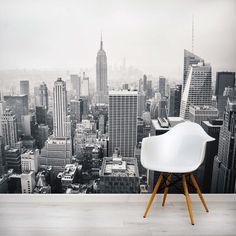 a white chair sitting in front of a large cityscape wallpapered with skyscrapers