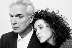 an older man and young woman are posing for a black and white photo with curly hair