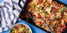 two plates of food on a blue table cloth and one plate with rice, vegetables and meat