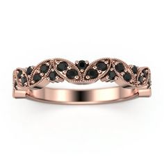 a rose gold wedding band with black diamonds in the center and an intricate design on top