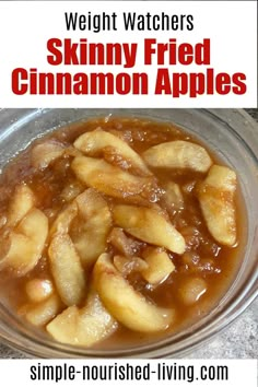 a glass bowl filled with cinnamon apples on top of a marble counter next to a red and white sign that says skinnyy fried cinnamon apples