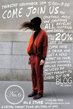 a woman standing on the sidewalk with her hair blowing in the wind, wearing an orange sweater and red pants