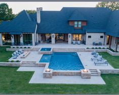 an aerial view of a house with a swimming pool and lounge chairs in the front yard