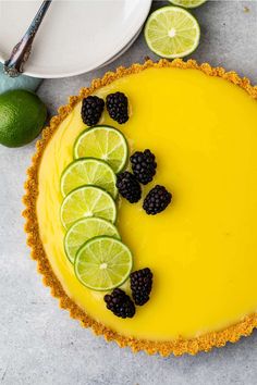 a lemon pie with limes and blackberries on top