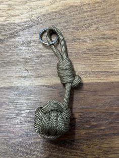 a knot is attached to a metal hook on a wooden table with wood flooring