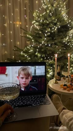 a person sitting in front of a laptop with a glass of wine on their lap