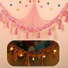 there is a pink string net with tassels hanging from it and stars on the wall