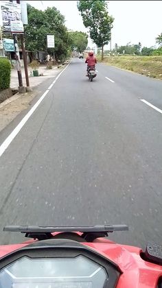 a person on a motor bike riding down the street