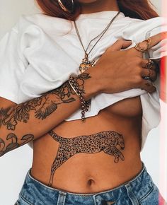 a woman with tattoos on her stomach holding onto a white t - shirt and jeans