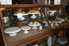 a display case filled with lots of different types of pastries and pies on top of glass shelves