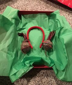 a pair of red headphones sitting on top of a green bag filled with paper