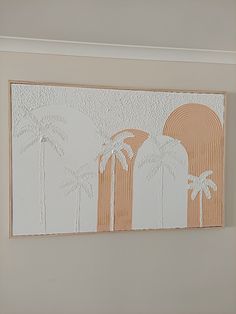 a painting with palm trees on it in a white and beige room by the wall