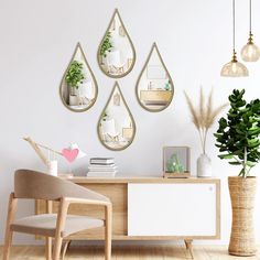 three mirrors hanging on the wall next to a table with a vase and plant in it