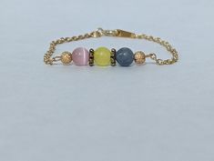 Bracelet designed in the colors of the Pansexual PRIDE flag. This flag is available in 2 patterns. All patterns are nickel and plastic free.  Pattern 1: Gold plated brass chain. The gemstones used are: 6mm pink cats-eye, 6mm yellow glass, 6mm blue aventurine. The accents used are 6mm metal flower spacers an gold star dusted crimp covers.  Pattern 2: Silver plated brass chain. The gemstones used are: 6mm rose quartz, 6 mm yellow glass, 6mm blue aventurine. The accents are black seed beads.  This Flag Bracelet, Pansexual Flag, Blue Aventurine, Pansexual Pride, Bracelets Design, Black Seed, Metal Flower, Cats Eye, Star Bracelet