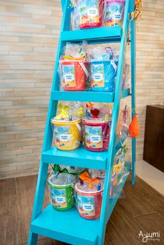 a blue shelf filled with lots of different types of items on top of a wooden floor