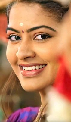 a close up of a person with a smile on her face and wearing a headdress