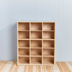 an empty wooden shelf against a wall with white stripes on the floor and blue walls behind it