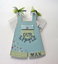 a paper cut out of a baby's overalls with the words our little man on it