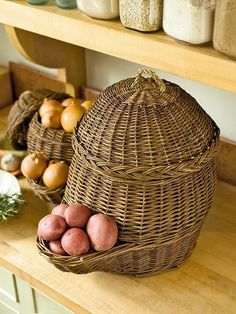 some potatoes are sitting in a basket on a counter next to other vegetables and jars