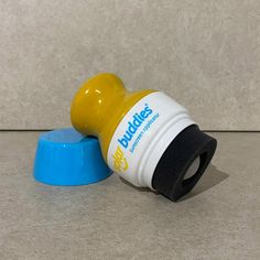 a yellow and blue bottle sitting on top of a counter next to a blue cup