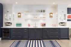 a kitchen with blue cabinets and white counter tops, striped rugs on the floor