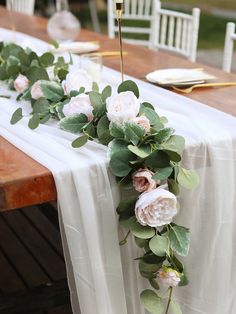 the table is set with flowers and greenery