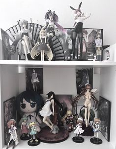 some anime figurines are sitting on a shelf