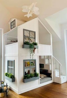 a doll house with plants growing in the windows and on top of it is a staircase