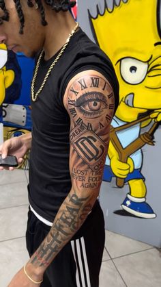 a man with tattoos on his arm holding a cell phone