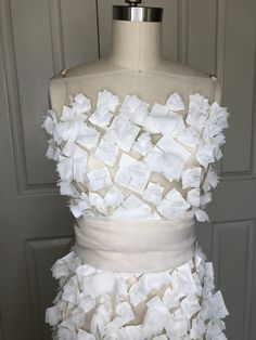 a dress made out of white fabric on a mannequin