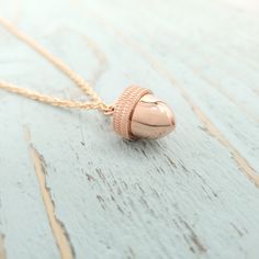 Acorn Necklace An Acorn with a Secret  - Capsule Container  Pendant Necklace I have always liked the simplicity and the symmetry of nature and the acorn is a perfect example of this.  This rose gold plated sterling silver acorn measures 14mm  in length and 13mm in diameter and has a lid that screws off to reveal a small container inside.  The possibilities are endless as to what you can put inside. Hung on a matching chain the length of your choice.  It's a great piece to layer with other my oth Acorn Necklace, Small Container, Urn Pendant, Urn Jewelry, Urn Necklaces, Charm Pendant Necklace, Memorial Jewelry, Rose Gold Necklace, Jewelry Gift Box