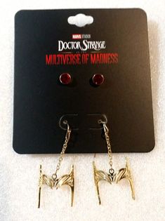 two pairs of earrings with chains hanging from it's ear hooks on top of a card