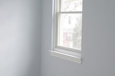 the corner of a room with a window and white paint on the walls is shown