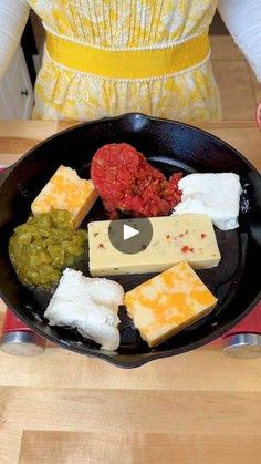 a pan filled with lots of different types of food on top of a wooden table