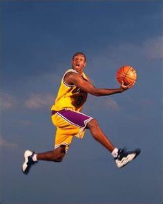 a man is jumping in the air with a basketball on his feet while wearing a yellow uniform