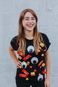 a woman wearing a black t - shirt with candy eyes and candies on it