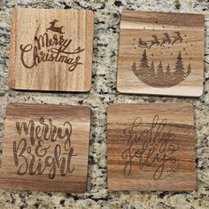 four wooden coasters with merry christmas designs on them sitting on a granite countertop