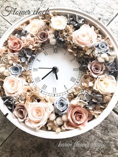 a clock made out of flowers on the floor with words above it that read, flower clock