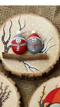 two painted eggs sitting on top of wooden slices