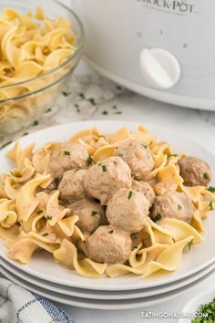 a white plate topped with pasta and meatballs next to an instant pot pressure cooker