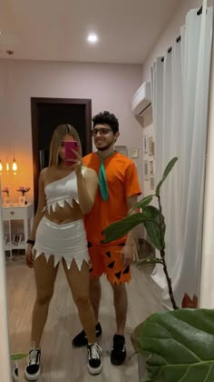 a man and woman in costumes taking a selfie