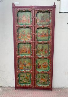 an ornate wooden door with paintings on it