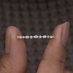 a woman's hand holding a diamond ring