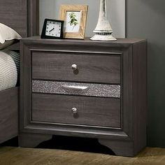 a night stand with two drawers and an alarm clock on the nightstand next to it