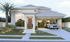 a white car is parked in front of a house that has palm trees and landscaping