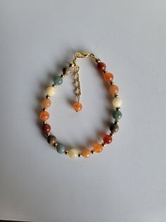 "This Fall bracelet features six opaque Fall colored gemstone beads. The colors are: yellow, orange, green, red, brown and light orange. The gemstones are:  Carnelian, Orange Calcite, Red Aventurine, Yellow Calcite, Burmese Jade and Picture Jasper. The remaining beads and findings are Gold-plated brass. This includes a 1\" extension and lobster claw clasp.  Custom Orders are always welcome! Ask about free sizing." Fall Themed Beaded Bracelet, Fall Bracelets Diy, Beaded Fall Jewelry, Autumn Accessories Jewelry, Diy Fall Jewelry Ideas, Fall Beaded Bracelet, Fall Jewelry Trends 2024, Colorful Beaded Bracelet, Diy Fall Jewelry