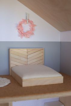 there is a bed with a wooden headboard on top of the table and a wreath above it